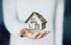 A midsection of a person holding a miniature house
